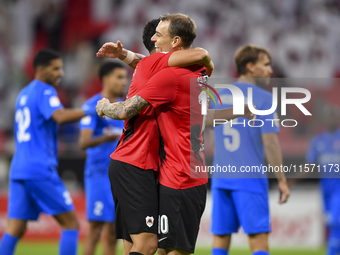 Mahmoud Ahmed Hassan (L) of Al Rayyan SC celebrates with his teammate after scoring a goal during the Ooredoo Qatar Stars League 24/25 match...