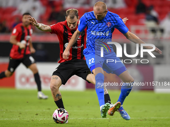 Roger Krug Guedes (L) of Al Rayyan SC battles for the ball with Andreas Van Beek (R) of Al Shahania SC during the Ooredoo Qatar Stars League...