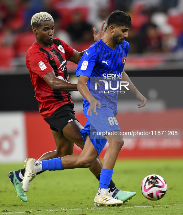 Thiago Henrique Mendes (L) of Al Rayyan SC battles for the ball with Andreas Van Beek (R) of Al Shahania SC during the Ooredoo Qatar Stars L...