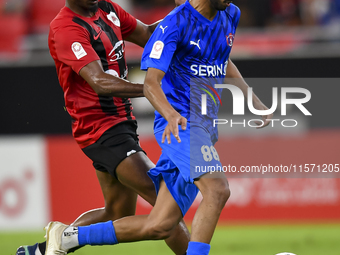 Thiago Henrique Mendes (L) of Al Rayyan SC battles for the ball with Andreas Van Beek (R) of Al Shahania SC during the Ooredoo Qatar Stars L...