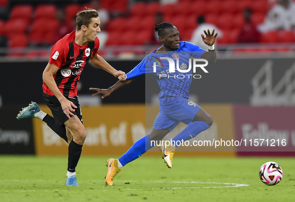 Julien Ariel De Sart (L) of Al Rayyan SC battles for the ball with Alhassan Koroma (R) of Al Shahania SC during the Ooredoo Qatar Stars Leag...