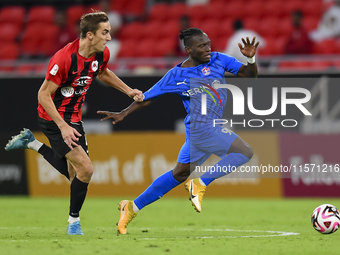 Julien Ariel De Sart (L) of Al Rayyan SC battles for the ball with Alhassan Koroma (R) of Al Shahania SC during the Ooredoo Qatar Stars Leag...