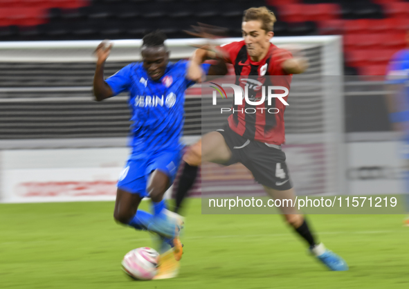 Julien Ariel De Sart (R) of Al Rayyan SC battles for the ball with Alhassan Koroma (L) of Al Shahania SC during the Ooredoo Qatar Stars Leag...