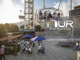 Iranian youths sit on a huge swing at Adrenaline Park in Tehran, Iran, on September 13, 2024. Amir Badri, an Iranian stuntman and award winn...