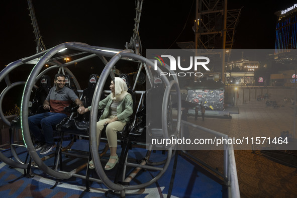 An Iranian couple sits on a huge swing at Adrenaline Park in Tehran, Iran, on September 13, 2024. Adrenaline Park is founded by Amir Badri,...