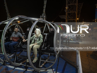 An Iranian couple sits on a huge swing at Adrenaline Park in Tehran, Iran, on September 13, 2024. Adrenaline Park is founded by Amir Badri,...