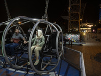 An Iranian couple sits on a huge swing at Adrenaline Park in Tehran, Iran, on September 13, 2024. Adrenaline Park is founded by Amir Badri,...