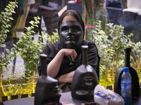 A young Iranian woman holds a mask in front of her face while playing Mafia, a party game, at a cafe at Adrenaline Park in Tehran, Iran, on...