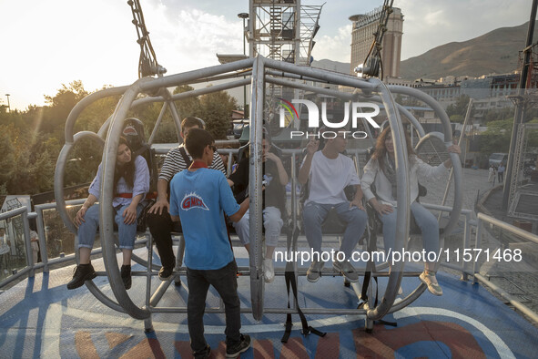 Iranian youths sit on a huge swing at Adrenaline Park in Tehran, Iran, on September 13, 2024. Amir Badri, an Iranian stuntman and award winn...