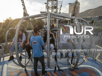 Iranian youths sit on a huge swing at Adrenaline Park in Tehran, Iran, on September 13, 2024. Amir Badri, an Iranian stuntman and award winn...