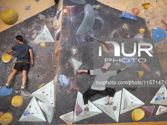 Two young Iranian rock climbers climb a wall at Adrenaline Park in Tehran, Iran, on September 13, 2024. Amir Badri, an Iranian stuntman and...