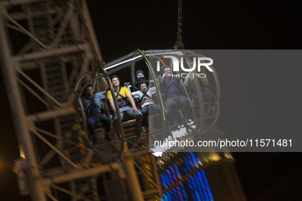 Iranian youths react while sitting on a huge swing at Adrenaline Park in Tehran, Iran, on September 13, 2024. Amir Badri, an Iranian stuntma...