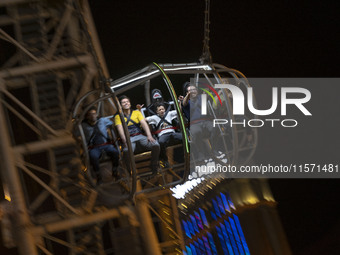 Iranian youths react while sitting on a huge swing at Adrenaline Park in Tehran, Iran, on September 13, 2024. Amir Badri, an Iranian stuntma...