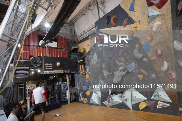 Two young Iranian rock climbers climb a wall at Adrenaline Park in Tehran, Iran, on September 13, 2024. Amir Badri, an Iranian stuntman and...