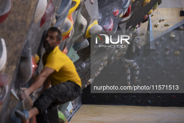 Two young Iranian rock climbers climb a wall at Adrenaline Park in Tehran, Iran, on September 13, 2024. Amir Badri, an Iranian stuntman and...