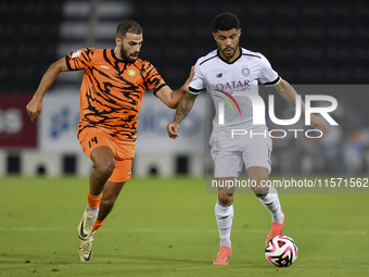 Paulo Silva (R) of Al-Sadd SC and Oussama Tannane (L) of Umm Salal SC are in action during the Ooredoo Qatar Stars League 24/25 match betwee...