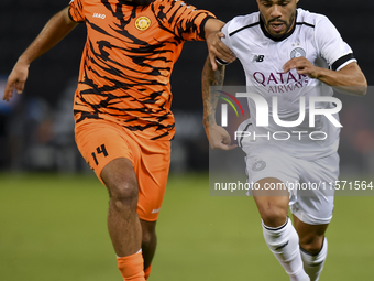 Paulo Silva (R) of Al-Sadd SC and Oussama Tannane (L) of Umm Salal SC are in action during the Ooredoo Qatar Stars League 24/25 match betwee...