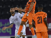 Mohammed Waad Albayati (L) of Al-Sadd SC and Antonio Mance (C) of Umm Salal SC are in action during the Ooredoo Qatar Stars League 24/25 mat...