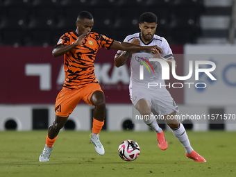 Paulo Silva (R) of Al-Sadd SC and Khalaf Saad Khalifa (L) of Umm Salal SC are in action during the Ooredoo Qatar Stars League 24/25 match be...