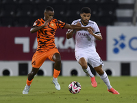 Paulo Silva (R) of Al-Sadd SC and Khalaf Saad Khalifa (L) of Umm Salal SC are in action during the Ooredoo Qatar Stars League 24/25 match be...