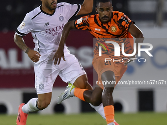 Paulo Silva (L) of Al-Sadd SC and Khalaf Saad Khalifa (R) of Umm Salal SC are in action during the Ooredoo Qatar Stars League 24/25 match be...