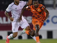 Paulo Silva (L) of Al-Sadd SC and Khalaf Saad Khalifa (R) of Umm Salal SC are in action during the Ooredoo Qatar Stars League 24/25 match be...