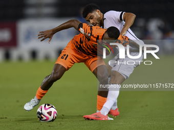 Paulo Silva (R) of Al-Sadd SC and Khalaf Saad Khalifa (L) of Umm Salal SC are in action during the Ooredoo Qatar Stars League 24/25 match be...