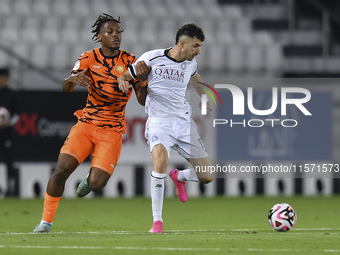 Rafael Sebastian Mujica Garcia (R) of Al-Sadd SC and Edidiong Nigerian (L) of Umm Salal SC are in action during the Ooredoo Qatar Stars Leag...