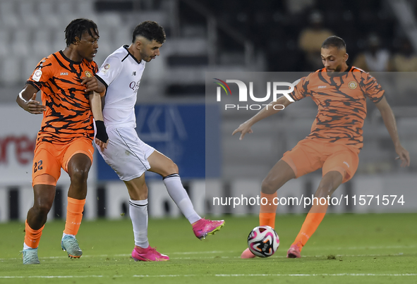 Rafael Sebastian Mujica Garcia (C) of Al-Sadd SC and Edidiong Nigerian (L) of Umm Salal SC are in action during the Ooredoo Qatar Stars Leag...