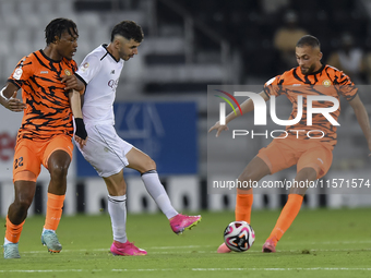 Rafael Sebastian Mujica Garcia (C) of Al-Sadd SC and Edidiong Nigerian (L) of Umm Salal SC are in action during the Ooredoo Qatar Stars Leag...