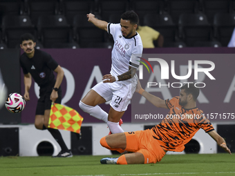 Giovani Henrique of Al-Sadd SC and Marouane Louadni of Umm Salal SC are in action during the Ooredoo Qatar Stars League 24/25 match between...