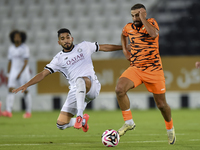 Mohammed Waad Albayati (L) of Al-Sadd SC battles for the ball with Oussama Tannane (R) of Umm Salal SC during the Ooredoo Qatar Stars League...