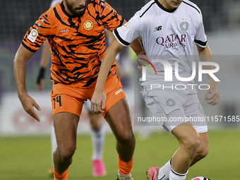 Moustafa Tarek Mashal (R) of Al-Sadd SC battles for the ball with Oussama Tannane (L) of Umm Salal SC during the Ooredoo Qatar Stars League...