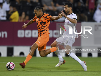 Boualem Khoukhi (R) of Al-Sadd SC battles for the ball with Kenji Joel (L) of Umm Salal SC during the Ooredoo Qatar Stars League 24/25 match...