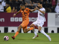 Boualem Khoukhi (R) of Al-Sadd SC battles for the ball with Kenji Joel (L) of Umm Salal SC during the Ooredoo Qatar Stars League 24/25 match...