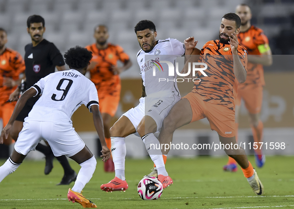 Paulo Silva (C) of Al-Sadd SC battles for the ball with Oussama Tannane (R) of Umm Salal SC during the Ooredoo Qatar Stars League 24/25 matc...