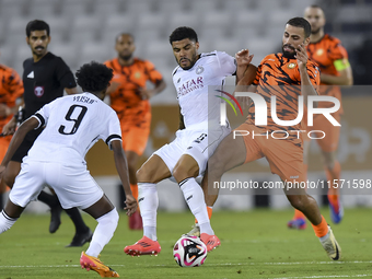 Paulo Silva (C) of Al-Sadd SC battles for the ball with Oussama Tannane (R) of Umm Salal SC during the Ooredoo Qatar Stars League 24/25 matc...