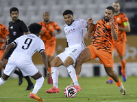 Paulo Silva (C) of Al-Sadd SC battles for the ball with Oussama Tannane (R) of Umm Salal SC during the Ooredoo Qatar Stars League 24/25 matc...