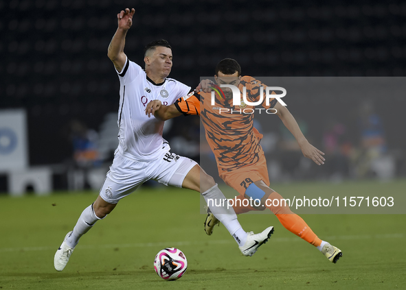 Andres Villa (L) of Al-Sadd SC battles for the ball with Ali Said Al-Muhannadi (R) of Umm Salal SC during the Ooredoo Qatar Stars League 24/...