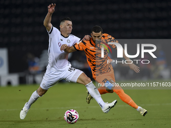 Andres Villa (L) of Al-Sadd SC battles for the ball with Ali Said Al-Muhannadi (R) of Umm Salal SC during the Ooredoo Qatar Stars League 24/...