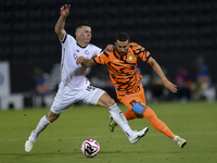 Andres Villa (L) of Al-Sadd SC battles for the ball with Ali Said Al-Muhannadi (R) of Umm Salal SC during the Ooredoo Qatar Stars League 24/...