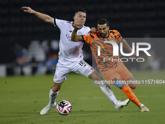 Andres Villa (L) of Al-Sadd SC battles for the ball with Ali Said Al-Muhannadi (R) of Umm Salal SC during the Ooredoo Qatar Stars League 24/...