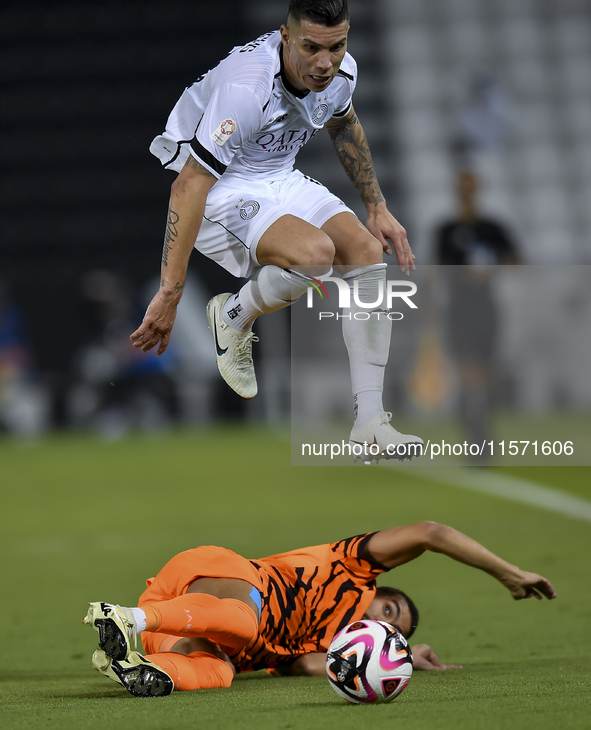 Andres Villa (top) of Al-Sadd SC battles for the ball with Ali Said Al-Muhannadi (R) of Umm Salal SC during the Ooredoo Qatar Stars League 2...