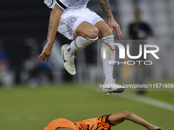 Andres Villa (top) of Al-Sadd SC battles for the ball with Ali Said Al-Muhannadi (R) of Umm Salal SC during the Ooredoo Qatar Stars League 2...