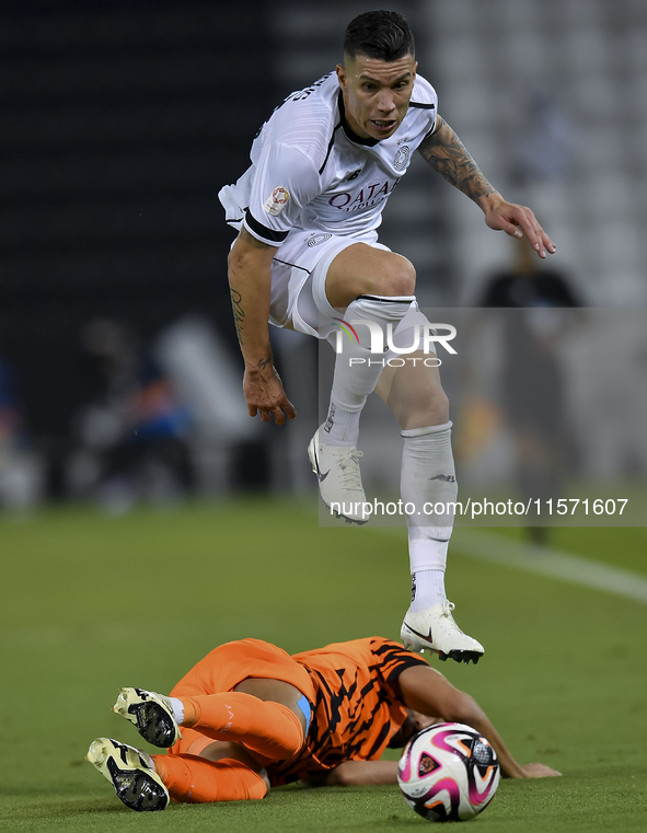 Andres Villa (top) of Al-Sadd SC battles for the ball with Ali Said Al-Muhannadi (R) of Umm Salal SC during the Ooredoo Qatar Stars League 2...