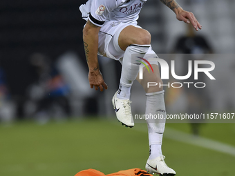 Andres Villa (top) of Al-Sadd SC battles for the ball with Ali Said Al-Muhannadi (R) of Umm Salal SC during the Ooredoo Qatar Stars League 2...