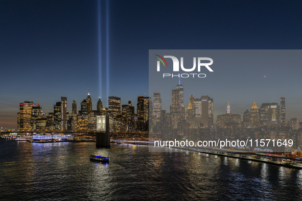 The annual Tribute in Light illuminates the skyline of lower Manhattan and One World Trade Center in New York City as it reflects in the top...