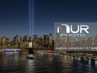 The annual Tribute in Light illuminates the skyline of lower Manhattan and One World Trade Center in New York City as it reflects in the top...