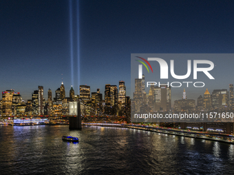 The annual Tribute in Light illuminates the skyline of lower Manhattan and One World Trade Center in New York City as it reflects in the top...