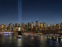 The annual Tribute in Light illuminates the skyline of lower Manhattan and One World Trade Center in New York City as it reflects in the top...